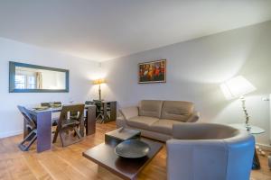 ein Wohnzimmer mit einem Sofa und einem Tisch in der Unterkunft Havre de paix - Appt avec terrasse in Courbevoie