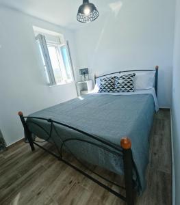 Schlafzimmer mit einem Bett mit blauer Decke in der Unterkunft Stone House in Sitia