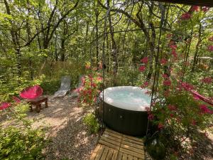 a hot tub in a garden with a bench and flowers at Ironvan in Bernac