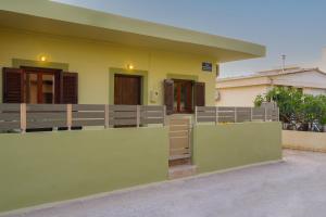 a house with a yellow and green exterior at Entire vacation house near beach in Gournes