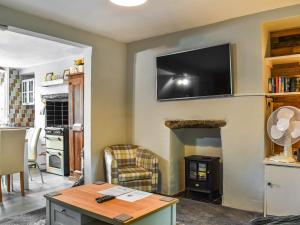 sala de estar con TV de pantalla plana en la pared en Beeswax Cottage en Dalton in Furness