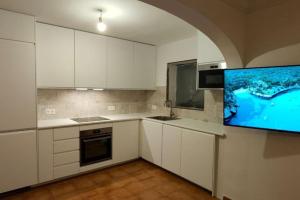 een keuken met witte kasten en een flatscreen-tv bij 3 Bedroom Villa, San Jaime, Son Bou in Son Bou