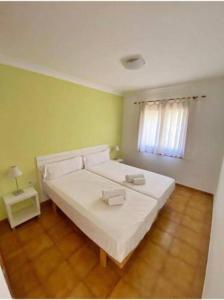 een slaapkamer met een wit bed en een raam bij 3 Bedroom Villa, San Jaime, Son Bou in Son Bou