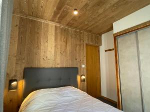 ヴァロワールにあるAppartement Valloire, 3 pièces, 6 personnes - FR-1-263-86の木製の壁のベッドルーム1室(ベッド1台付)