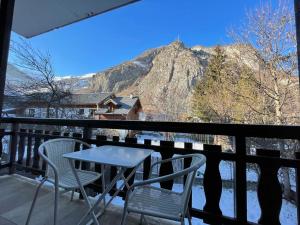 a table and chairs on a balcony with a mountain at 3 pièces, 2 chambres, balcon et parking, pour 6 personnes - FR-1-263-89 in Valloire