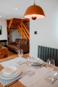 a table with plates and wine glasses on it at Brecon Cottage A Luxury Hikers Retreat in Brecon
