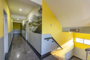 a hallway with yellow walls and stairs in a building at JC Woodville Manor in Kodaikānāl +116 photos