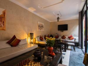 a living room with a couch and a table at Riad Le Bel Oranger in Marrakech