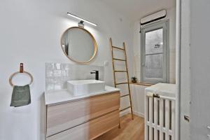 un bagno con lavandino e specchio di Au coeur des Platanes - Parking Gratuit Sous-Terrain - CLiM - Balcon ad Avignone