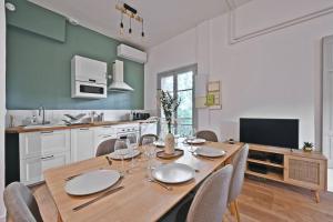 una sala da pranzo con tavolo e sedie in legno di Au coeur des Platanes - Parking Gratuit Sous-Terrain - CLiM - Balcon ad Avignone Altre 33 foto