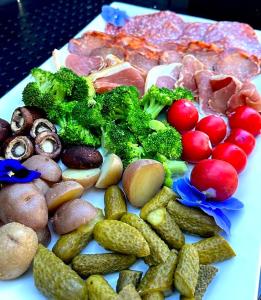 a plate of food with vegetables and meat at The Secret Garden Inn in Kingston