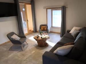 ein Wohnzimmer mit einem Sofa und einem Tisch in der Unterkunft Chez Léon in Samoëns