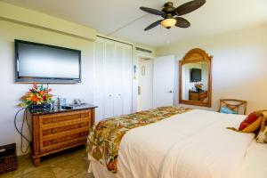 a bedroom with a bed and a flat screen tv at Kaanapali Shores 448 in Kaanapali +28 photos