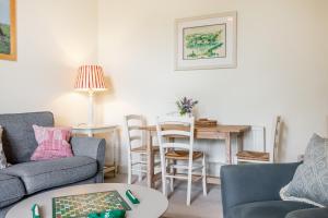 uma sala de estar com um sofá e uma mesa em Giddy Cottage em East Dean
