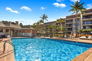a pool at a resort with palm trees and condos at Kaanapali Shores 448 in Kaanapali