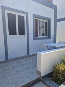 a patio with a white door and a table at Suloti House Lungomare in Vlorë