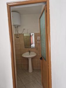 a bathroom with a sink and a toilet and a mirror at Suloti House Lungomare in Vlorë