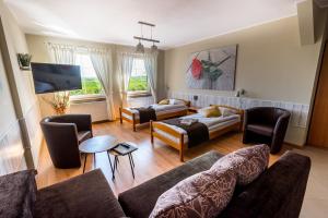 a living room with a couch and chairs and a tv at Zajazd Avena in Krokowa