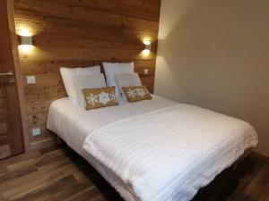 ein großes weißes Bett mit zwei Kissen darauf in der Unterkunft Chez Léon in Samoëns