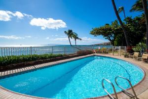 a swimming pool with the ocean in the background at Hono Kai C12 in Maalaea