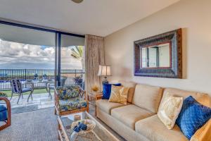 a living room with a couch and a view of the ocean at Kahana Reef 106 in Kahana