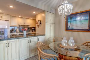 a kitchen with a table and chairs and a chandelier at Kahana Reef 106 in Kahana +15 photos