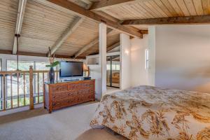 a bedroom with a bed and a flat screen tv at Hono Kai C8 in Wailuku