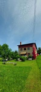 a large brick house in a field of green grass at Posada los Taranos in Valdaliga 