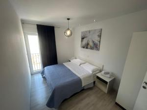 1 dormitorio con 1 cama y luz colgante en Apartments Pivac, en Makarska