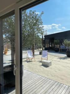 a sliding glass door with two chairs on a deck at Skyfall Rooms in Eisenstadt