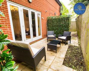 a patio with chairs and tables and a building at 2 Bedroom House By Cabral Properties Monthly special price in Reading