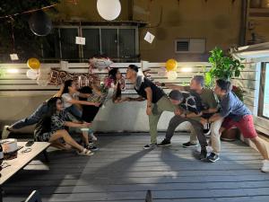 un groupe de personnes posant une photo sur un patio dans l'établissement דירת סטודיו יפיפיה על גג ומרפסת שמש ברחוב הירקון, à Tel Aviv