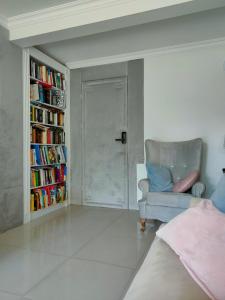 a living room with a couch and a book shelf at Fryderyk in Krynica Morska