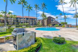 a resort with a swimming pool and palm trees at Papakea B204 in Lahaina
