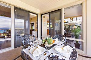 a dining room with a table on a balcony at Kapalua Bay Villa 24G2 in Honokahua