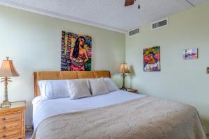 Un dormitorio con una cama y dos cuadros en la pared. en Maui Kai 801, en Kahana 21 fotos más