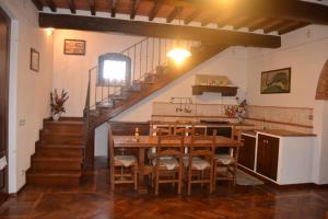 コルトーナにあるCortona Holiday Homeのキッチン、ダイニングルーム(テーブル、階段付)