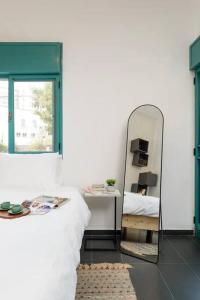 ein Schlafzimmer mit einem Spiegel und einem Bett in der Unterkunft Vintage Getaway by the beach in Tel Aviv