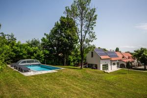 a house with a swimming pool in the yard at Oszter Udvarház in Kékkút