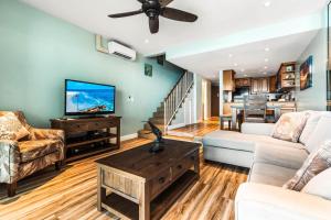 un salon avec un canapé et une télévision dans l'établissement Noelani 309, à Kahana