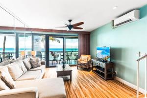 un salon avec un canapé et une télévision dans l'établissement Noelani 309, à Kahana