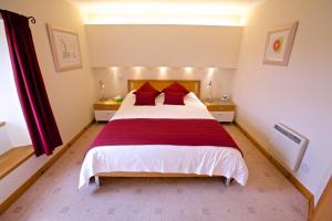 a bedroom with a large bed with red pillows at Sebay Mill Holiday Apartments in Toab