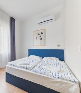 a bed with a blue headboard in a bedroom at Villa Oliver Budapest in Budapest