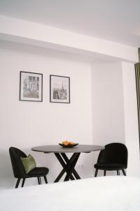 a table and chairs in a room with white walls at Green Flat Düsseldorf First in Düsseldorf