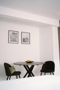 a table and chairs in a room with white walls at Green Flat Düsseldorf First in Düsseldorf +9 photos