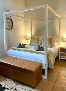a bedroom with a white canopy bed with a ottoman at Pat Busch Mountain Reserve in Robertson