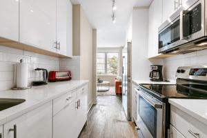 a white kitchen with white cabinets and appliances at Elegant Studio Near French Quarter in New Orleans