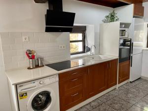 a kitchen with a washing machine and a sink at Casa Mariyina in Ribadesella