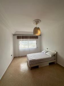 a bedroom with a bed and a large window at Vaste appartement au centre de Tetouan in Tetouan
