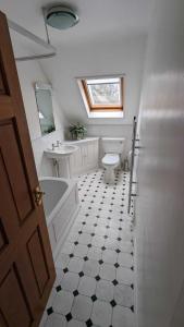 a bathroom with a toilet and a sink and a tub at Cotteswold House in Bibury